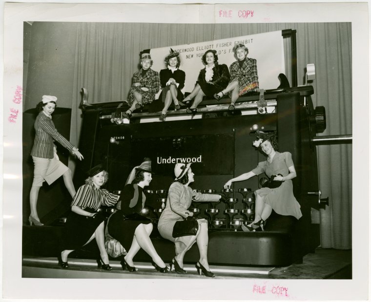 Women posing with giant typewriter