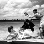 "Single Slide-only one slider. Hook slide into home plate during Ft. Wayne inter-team practice game on Opalocka diamond: Marg Callaghan, 26, from Vancouver (5th year in league 4th coming up with Ft. Wayne) as second baseman, slides in on close play--umpire Norris Ward whose 4th year in league is coming up, watches play closely. Vivian Kellog, catcher from Jackson, Mich., reaches for ball coming in fast." (Florida Memory)