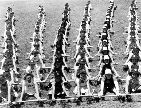 Calisthenics-rowing exercise. Girls sitting in 6 rows, each club to a row, form pattern on field during daily calisthenics program, as rigorous as a major league's farm training camp. Clubs included in picture are Fort Wayne, South Bend, Peoria, Rockford, Springfield, and Chicago. Photo Credit: Florida Memory