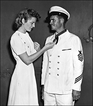 Alice Finn admires the Medal of Honor awarded to her husband for his counterattack during the Japanese raid on Pearl Harbor.