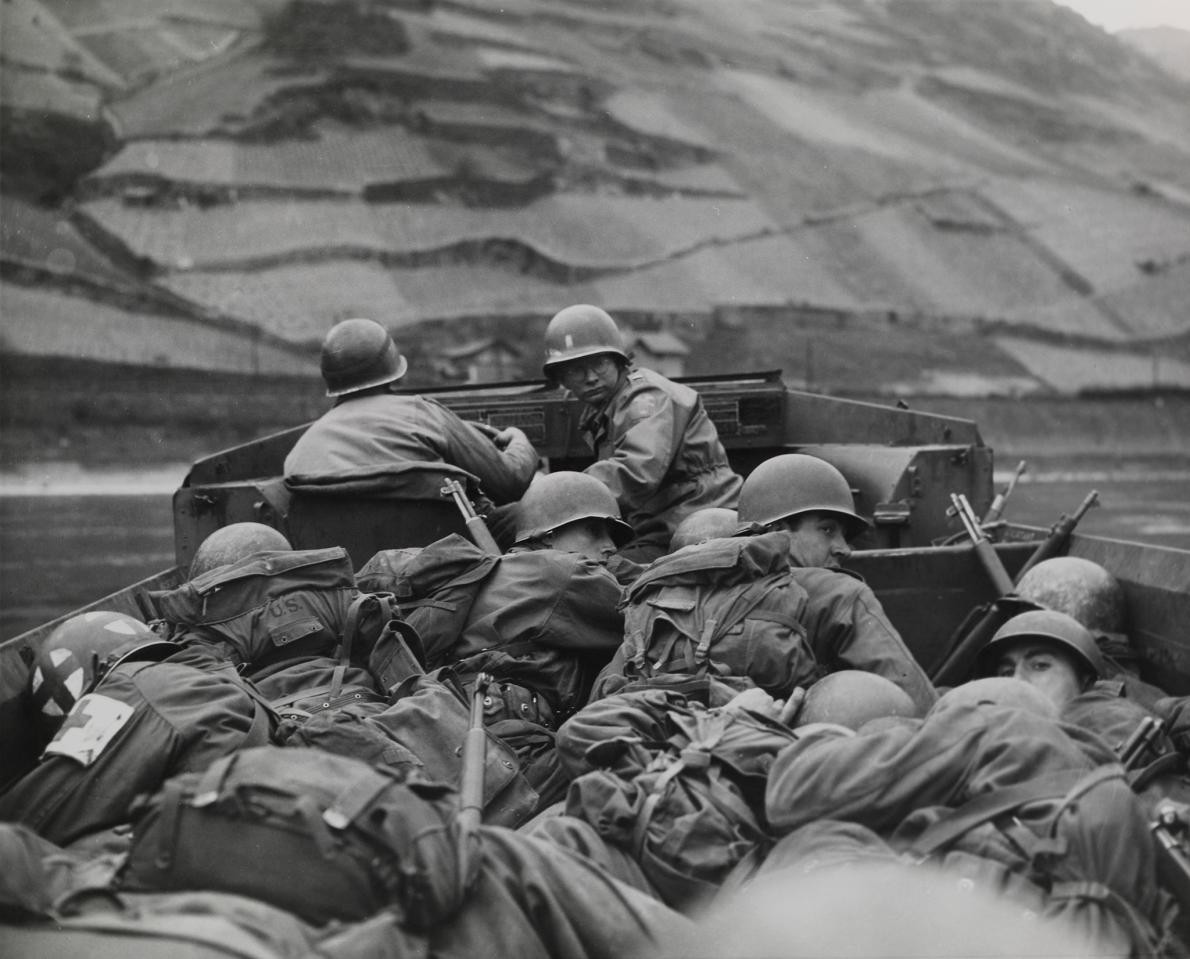 Crouching low in a DUKW for concealment and protection, men of the 89th division, U.S. Third Army, cross the Rhine River at Oberwesel, Germany. March 26, 1945.